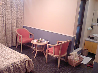 松山市/Labyrinth (ホテル ラヴィリンス)/203号室/ベッド脇のテーブルと椅子
